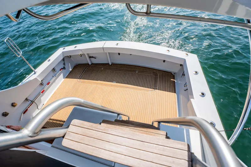 Denise Catherine Yacht Photos Pics 1991 Jersey 42 Convertible Sportfisherman boat deck with wooden flooring and ocean view.