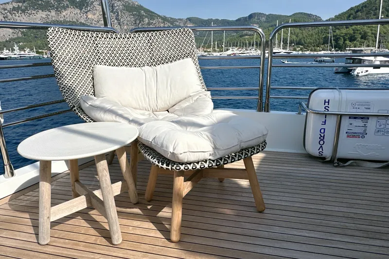 Swordfish 68 Yacht Photos Pics Luxurious Sunseeker 90 Yacht 2009 deck with cushioned chair and table, scenic marina view.