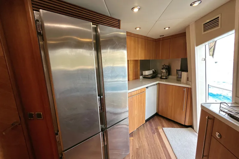 Swordfish 68 Yacht Photos Pics Modern kitchen interior on 2009 Sunseeker 90 Yacht with stainless steel appliances and wooden cabinetry.