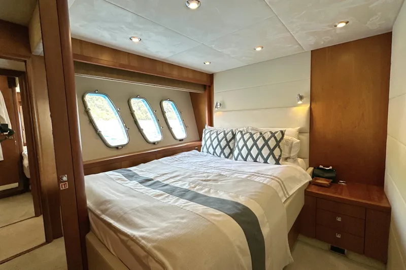 Swordfish 68 Yacht Photos Pics Luxurious bedroom interior of 2009 Sunseeker 90 Yacht with elegant bedding and porthole windows.