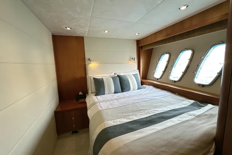 Swordfish 68 Yacht Photos Pics Luxurious bedroom interior of 2009 Sunseeker 90 Yacht with elegant bedding and porthole windows.
