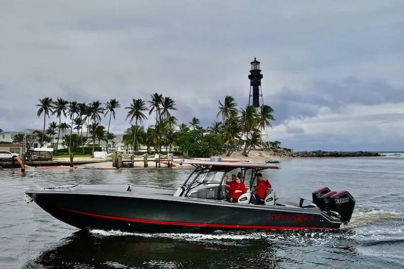  Yacht Photos Pics 2025 Nor-Tech 390 Sport Center Console boat cruising near a lighthouse and palm trees.