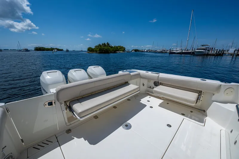 Yacht Photos Pics 2015 Boston Whaler 345 Conquest boat deck with seating, overlooking a marina and blue sky.