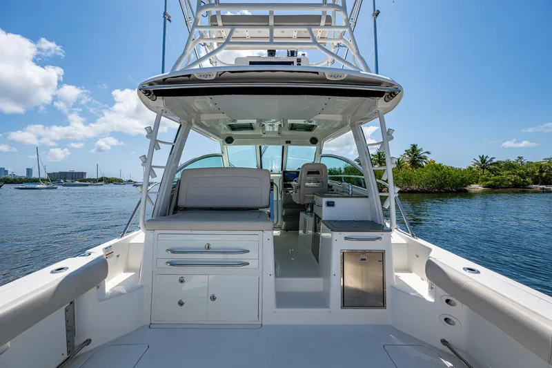 Yacht Photos Pics 2015 Boston Whaler 345 Conquest boat interior with seating and storage, docked by scenic waterway.