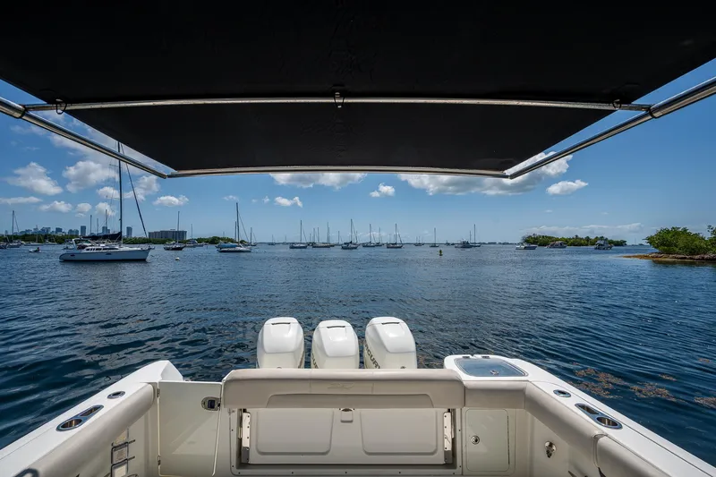  Yacht Photos Pics Boston Whaler 345 Conquest 2015 boat with triple engines, overlooking a serene marina.