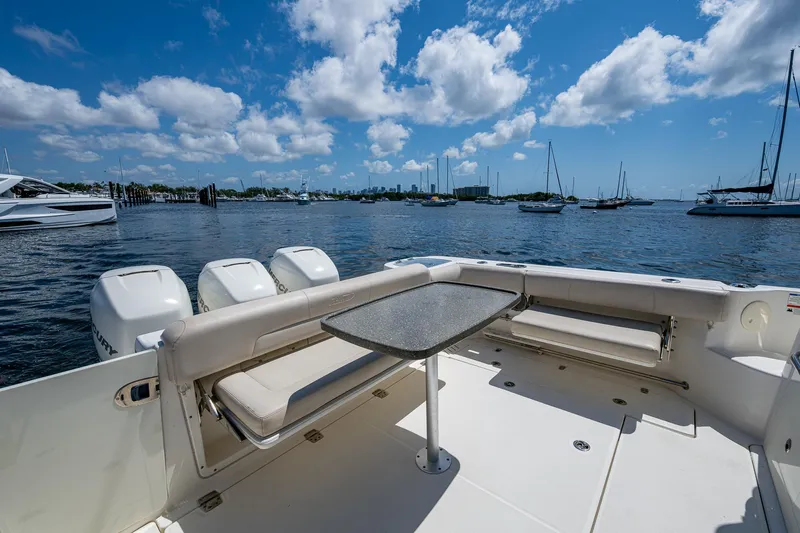  Yacht Photos Pics 2015 Boston Whaler 345 Conquest boat interior with seating and table, docked on a sunny day.