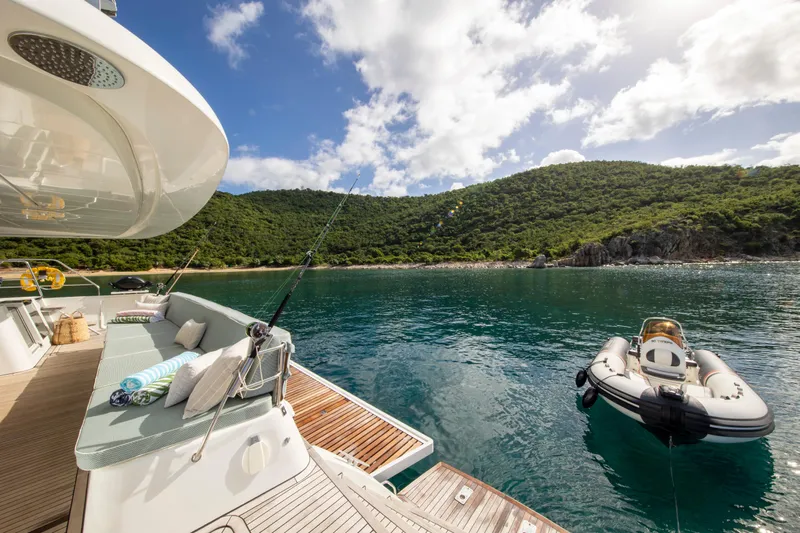 Nomada Yacht Photos Pics Lagoon 620 yacht, 2014 model, anchored in serene bay with lush green hills.