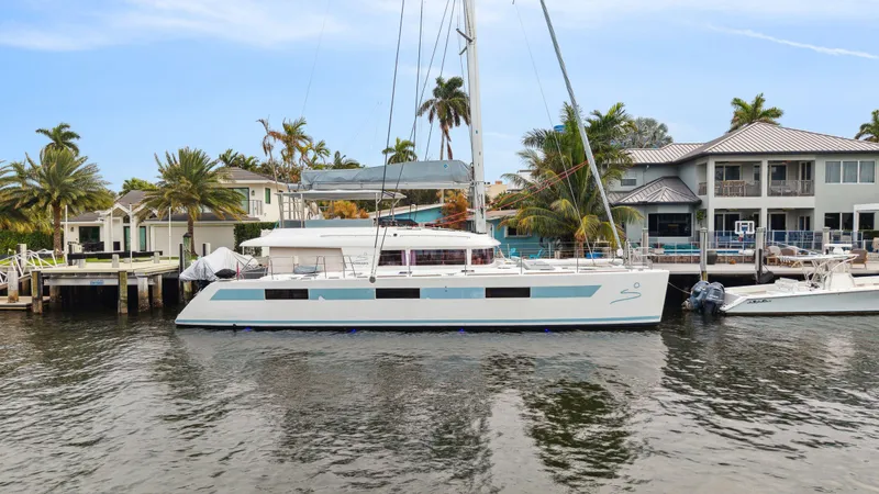 Nomada Yacht Photos Pics Lagoon 620 catamaran docked by waterfront homes, 2014 model.