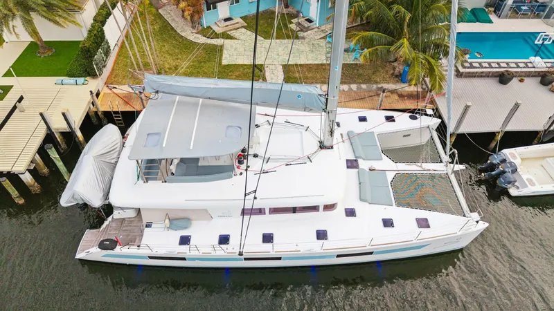 Nomada Yacht Photos Pics 2014 Lagoon 620 catamaran docked near waterfront property, aerial view.