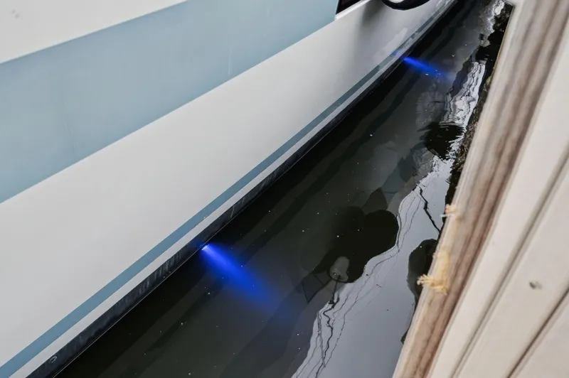 Nomada Yacht Photos Pics Lagoon 620 yacht with underwater blue lights, 2014 model, docked in calm water.