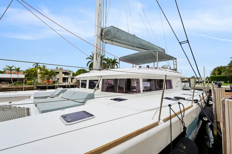 Nomada Yacht Photos Pics 2014 Lagoon 620 catamaran docked, featuring sleek design and spacious deck under clear skies.