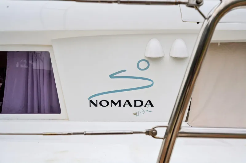 Nomada Yacht Photos Pics Lagoon 620 catamaran, 2014 model, featuring "Nomada" logo on the side.