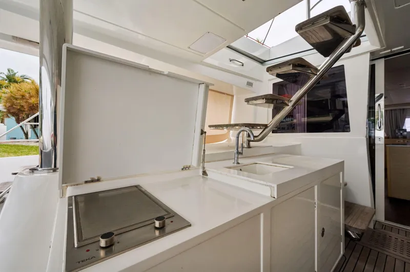 Nomada Yacht Photos Pics Outdoor kitchen area on a 2014 Lagoon 620 yacht, featuring a sink and stove.
