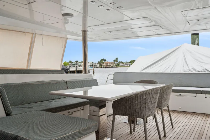 Nomada Yacht Photos Pics Lagoon 620 yacht 2014, spacious deck with seating and table, waterfront view.