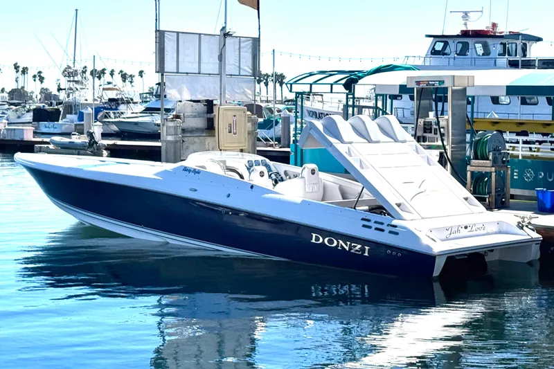 Jah Love Yacht Photos Pics 2015 Donzi 38 ZR speedboat docked at marina, reflecting on calm water.
