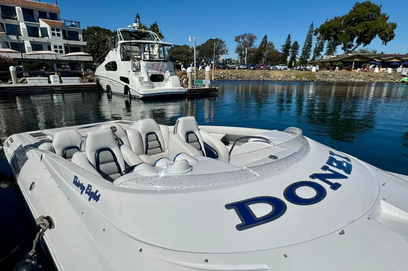 Jah Love Yacht Photos Pics 2015 Donzi 38 ZR speedboat docked in a marina, with luxury yacht in background.