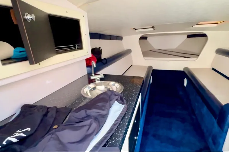 Jah Love Yacht Photos Pics Interior of 2015 Donzi 38 ZR boat with kitchenette and seating area.