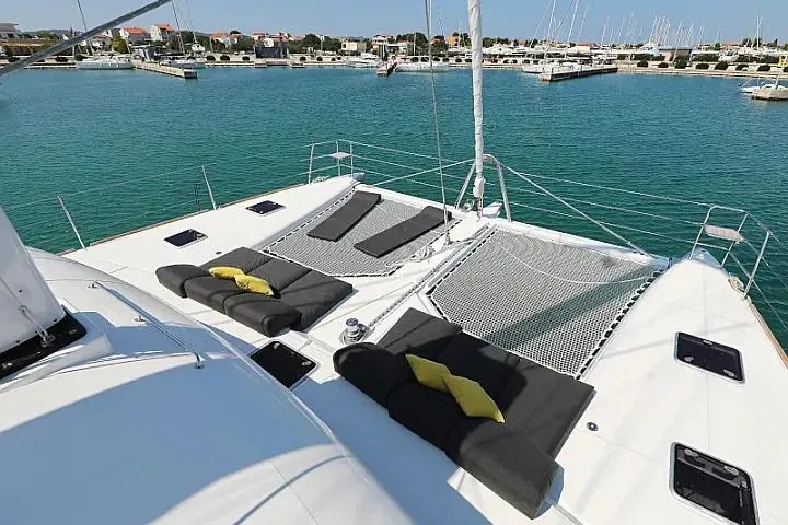 Masterdream Yacht Photos Pics Luxury Lagoon 620 Esense yacht deck with sun loungers, 2018 model, in a marina setting.