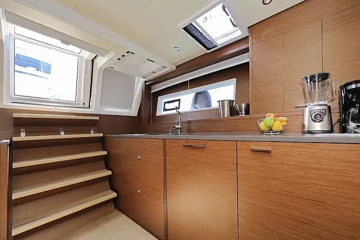 Masterdream Yacht Photos Pics Modern kitchen interior of 2018 Lagoon 620 Esense yacht with wooden cabinets and appliances.
