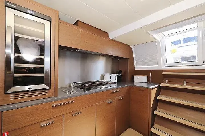 Masterdream Yacht Photos Pics Modern kitchen interior of 2018 Lagoon 620 Esense yacht with wooden cabinetry and appliances.