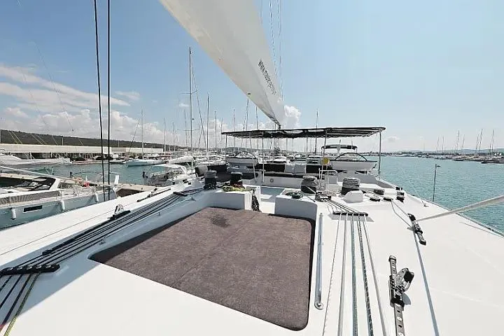 Masterdream Yacht Photos Pics 2018 Lagoon 620 Esense catamaran docked in a marina, showcasing spacious deck and sail.