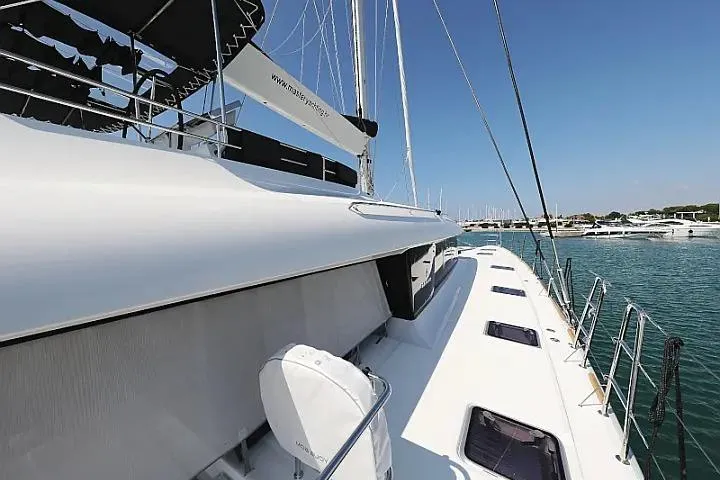 Masterdream Yacht Photos Pics 2018 Lagoon 620 Esense yacht docked at marina, showcasing sleek design and spacious deck.
