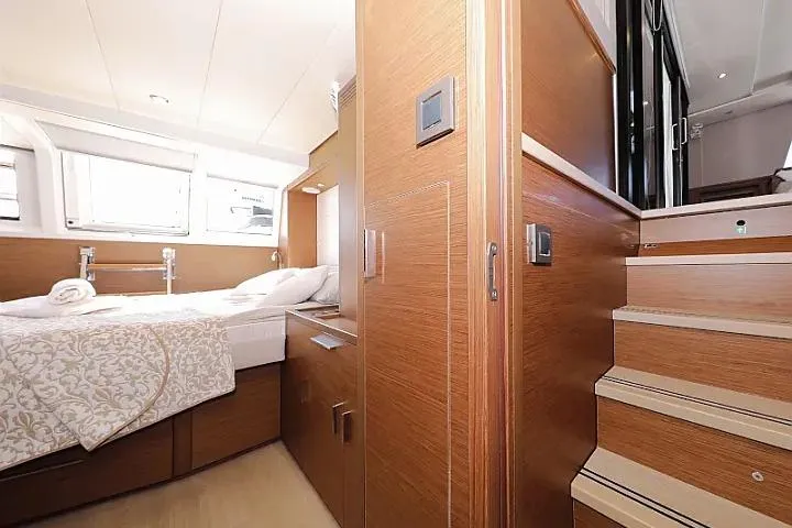 Masterdream Yacht Photos Pics Luxurious interior of 2018 Lagoon 620 Esense yacht cabin with wooden finish and cozy bedding.