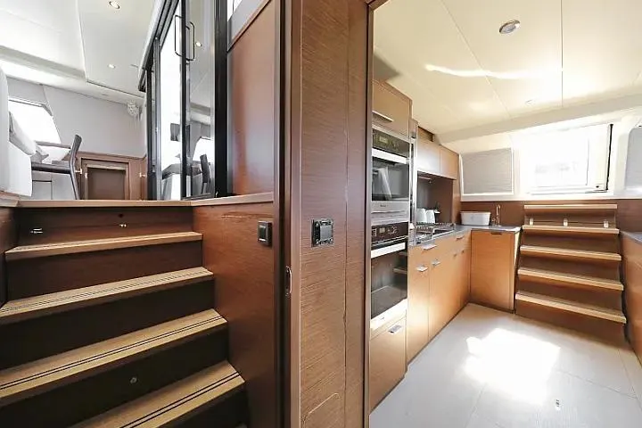Masterdream Yacht Photos Pics Interior of 2018 Lagoon 620 Esense yacht with modern kitchen and wooden stairs.
