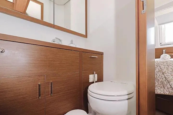 Masterdream Yacht Photos Pics Modern bathroom in 2018 Lagoon 620 Esense yacht with wooden cabinetry and white fixtures.