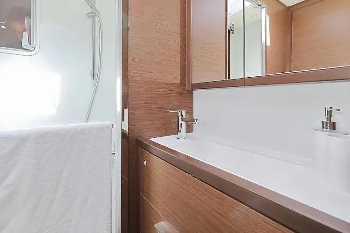 Masterdream Yacht Photos Pics Modern bathroom interior on 2018 Lagoon 620 Esense yacht, featuring sleek wood finishes and a glass shower.
