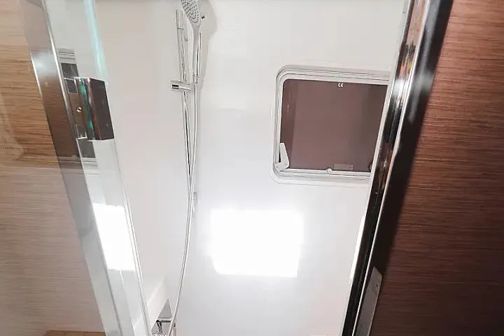Masterdream Yacht Photos Pics Interior shower area of 2018 Lagoon 620 Esense yacht with window and modern fixtures.