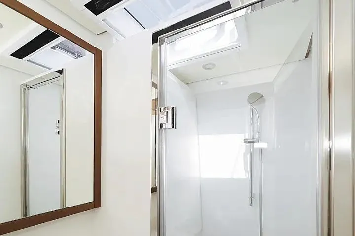 Masterdream Yacht Photos Pics Modern shower area in 2018 Lagoon 620 Esense yacht, featuring sleek glass door and mirror.