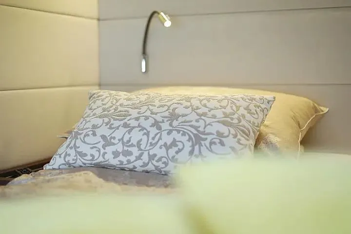 Masterdream Yacht Photos Pics Luxurious bedroom interior on Lagoon 620 Esense yacht, featuring elegant pillows and modern lighting.