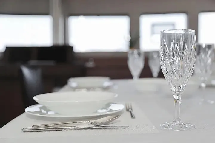 Masterdream Yacht Photos Pics Elegant dining setup on Lagoon 620 Esense yacht, featuring crystal glassware and fine tableware.
