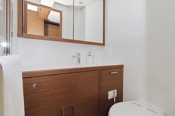 Masterdream Yacht Photos Pics Modern bathroom interior on 2018 Lagoon 620 Esense yacht, featuring wood cabinetry and sleek fixtures.