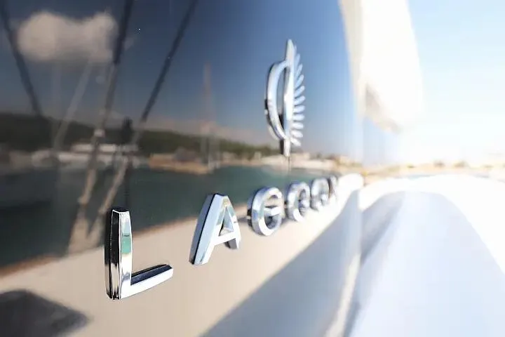 Masterdream Yacht Photos Pics Close-up of Lagoon 620 Esense yacht logo, 2018 model, reflecting marina scenery.