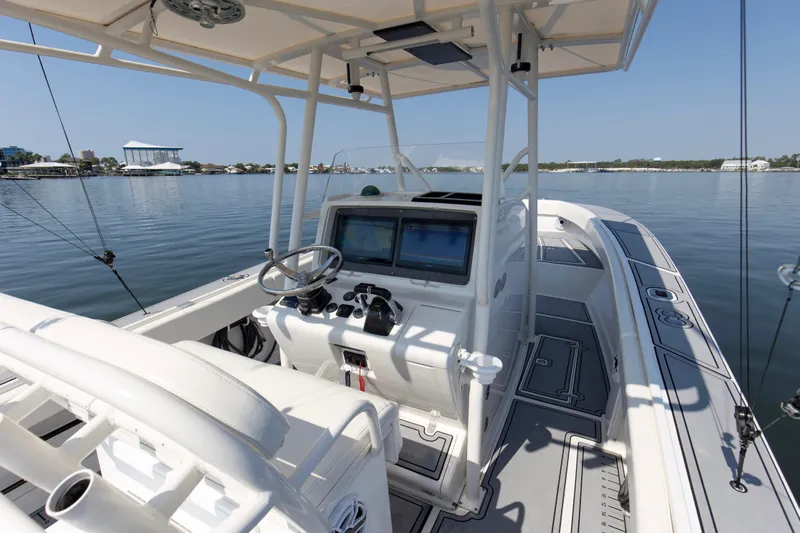 Smoke Show Yacht Photos Pics 2004 Jupiter 31 FS boat interior with steering wheel and navigation screens on calm water.