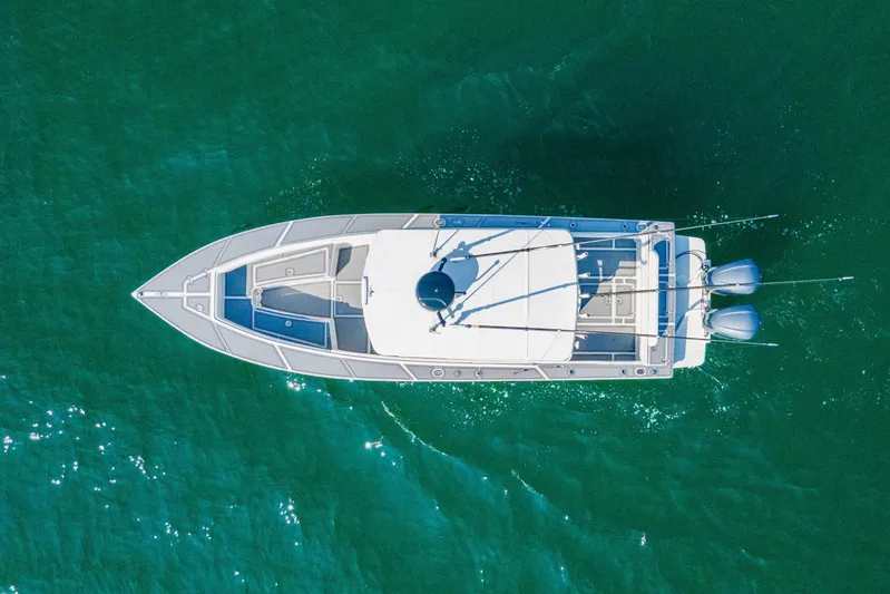 Smoke Show Yacht Photos Pics Aerial view of 2004 Jupiter 31 FS boat on clear green water.