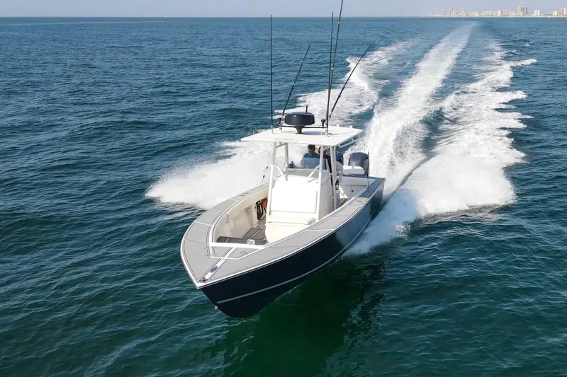 Smoke Show Yacht Photos Pics 2004 Jupiter 31 FS boat cruising on open water, leaving a wake behind.