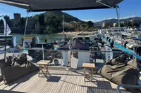 Deck view from 2023 Absolute 60 Fly yacht overlooking marina and scenic coastline.
