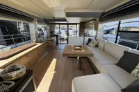 Luxurious interior of 2023 Absolute 60 Fly yacht with modern furnishings and large windows.