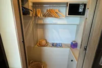 2023 Absolute 60 Fly yacht interior closet with hangers, basket, and storage.
