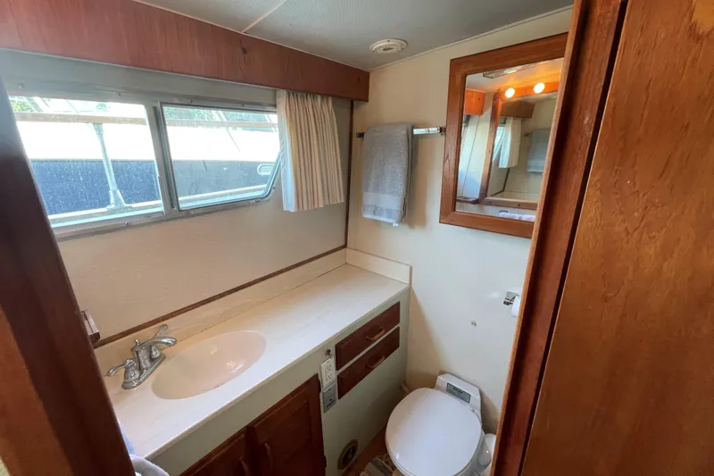  Yacht Photos Pics 1980 Tollycraft 48 Cockpit Motor Yacht bathroom with sink, mirror, and window.