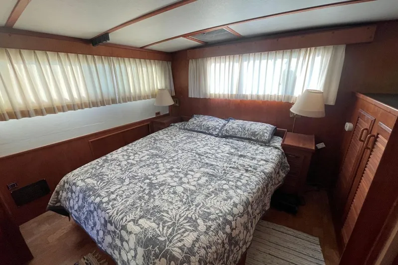  Yacht Photos Pics 1980 Tollycraft 48 Cockpit Motor Yacht bedroom with floral bedding and wooden interior.