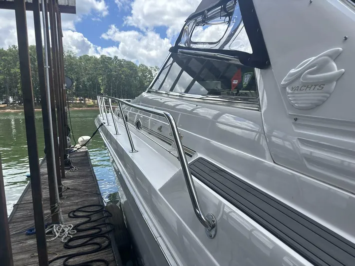 Forget About It Yacht Photos Pics 1996 Sea Ray 500 Sundancer yacht docked by a serene lake.