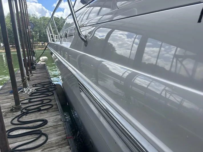 Forget About It Yacht Photos Pics 1996 Sea Ray 500 Sundancer yacht docked, reflecting water and sky.