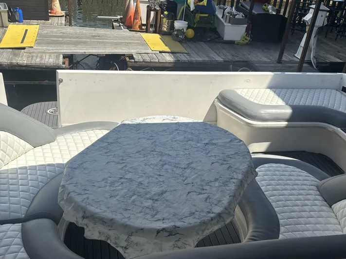 Forget About It Yacht Photos Pics 1996 Sea Ray 500 Sundancer yacht interior with cushioned seating and a covered table.