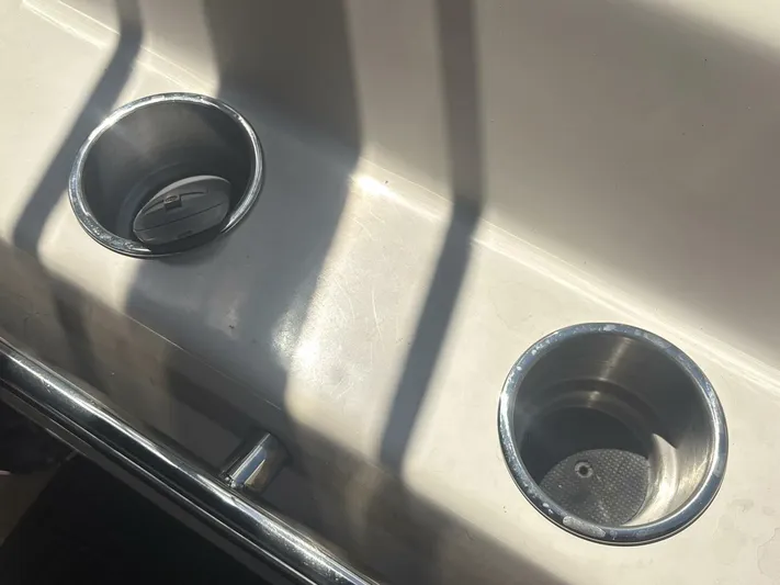 Forget About It Yacht Photos Pics Cup holders on a 1996 Sea Ray 500 Sundancer boat, reflecting sunlight.