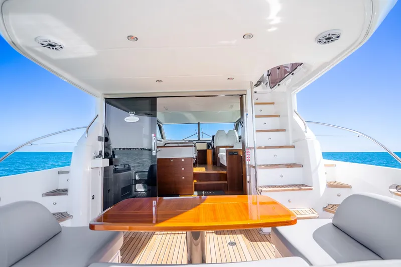 Chill Yacht Photos Pics Luxurious 2018 Princess F49 yacht interior with wooden table, ocean view, and modern seating.