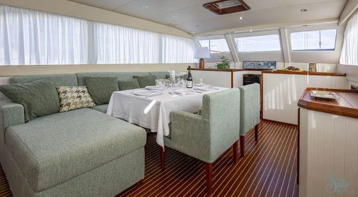 Sally Yacht Photos Pics Luxurious interior of a 1959 Burger 60 yacht with elegant dining area and plush seating.